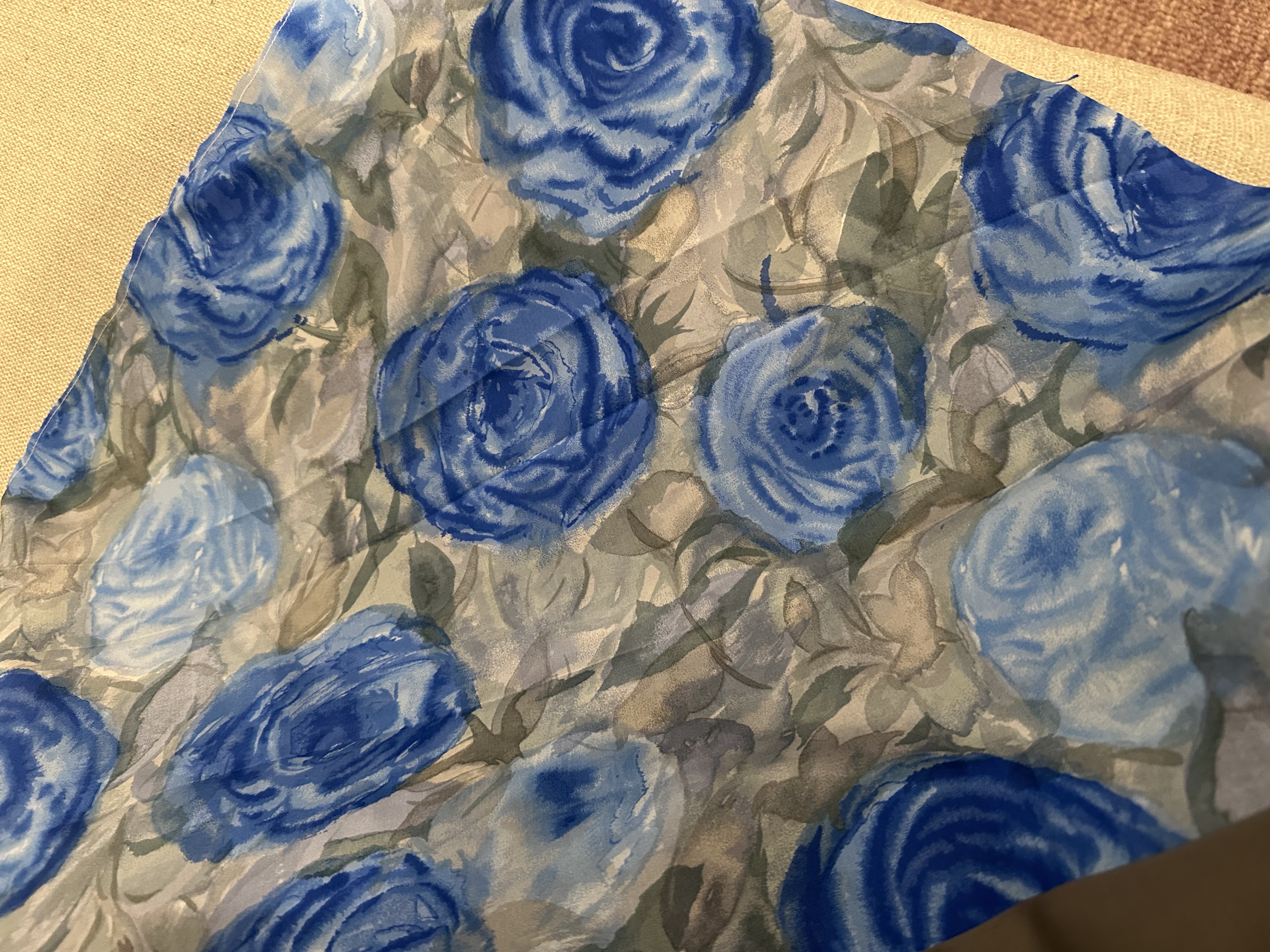Close-up of the grey-blue silky fabric with a blue rose print